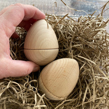 Load image into Gallery viewer, Two part wood egg with hand for scale

