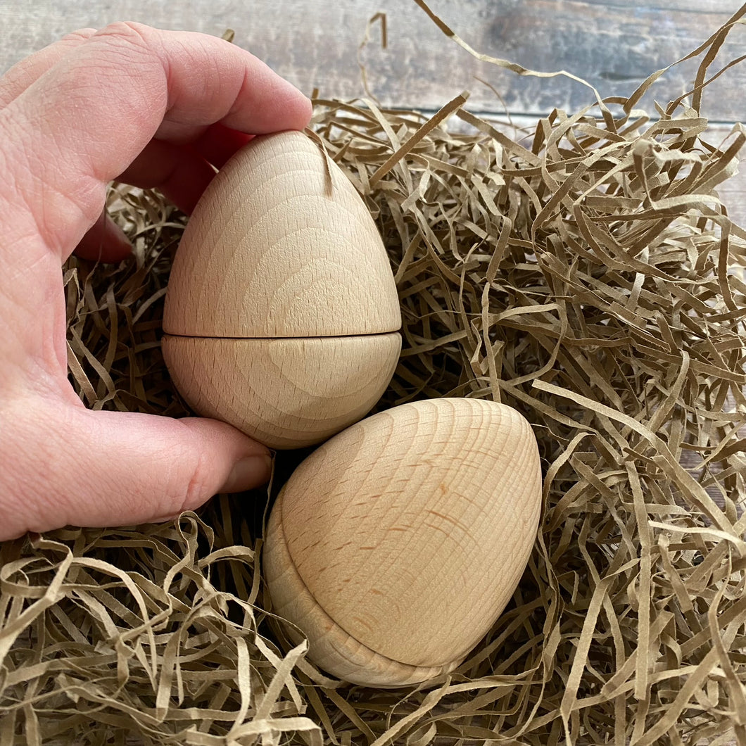 Two part wood egg with hand for scale